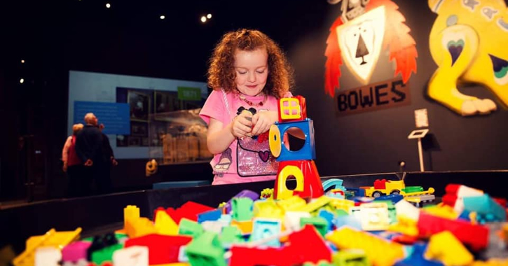 girl playing with lego in bowes museum